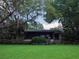 Charming home featuring a screened-in porch surrounded by lush greenery and a well-maintained lawn at 6084 Masters Blvd, Orlando, FL 32819