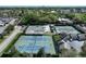Aerial view of multiple tennis courts with well-maintained landscaping, shaded pavilions, and ample parking at 6084 Masters Blvd, Orlando, FL 32819