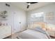 Cozy bedroom featuring neutral colors, wood floors, a large window, and white furniture at 730 Georgia Ave, Longwood, FL 32750