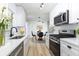 Modern kitchen featuring white cabinetry, stainless steel appliances, and an adjacent dining area at 730 Georgia Ave, Longwood, FL 32750
