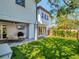 Landscaped backyard with manicured lawn, covered patio, barbecue grill, and outdoor seating at 804 E 24Th Ave, New Smyrna Beach, FL 32169