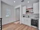Stylish bar area with white cabinets, open shelving, a beverage cooler, and unique backsplash at 804 E 24Th Ave, New Smyrna Beach, FL 32169