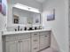 Stylish bathroom vanity featuring gray cabinetry, double sinks, and quartz countertops at 804 E 24Th Ave, New Smyrna Beach, FL 32169