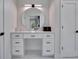 Bathroom vanity area features a round mirror, white cabinets and black hardware at 804 E 24Th Ave, New Smyrna Beach, FL 32169