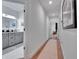 Hallway leads to a bathroom with gray cabinetry and a bedroom at the end of the hall at 804 E 24Th Ave, New Smyrna Beach, FL 32169