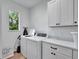 Bright laundry room with white cabinets, countertop, modern appliances, and a window at 804 E 24Th Ave, New Smyrna Beach, FL 32169