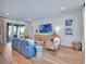 A living room has sliding glass doors, a TV, light wood furniture, and bright natural light at 804 E 24Th Ave, New Smyrna Beach, FL 32169