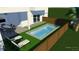 A modern, rectangular pool surrounded by a wooden fence and outdoor furniture, perfect for relaxation and entertainment at 804 E 24Th Ave, New Smyrna Beach, FL 32169