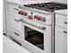 Close up of a modern white range with copper accents and a stainless steel cooktop in a bright kitchen at 804 E 24Th Ave, New Smyrna Beach, FL 32169