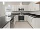 Modern kitchen with stainless steel appliances, granite countertops, and sleek white cabinetry at 805 S Locust Ave, Sanford, FL 32771