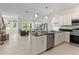Modern kitchen features white cabinetry, stainless steel appliances, and an island with a black countertop at 805 S Locust Ave, Sanford, FL 32771