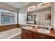 Bathroom with double sinks, large mirror, soaking tub and window at 8111 Pacific Loon St, Winter Garden, FL 34787