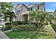 Attractive two-story home showcasing tropical landscaping, a covered front porch, and a neatly maintained lawn at 8111 Pacific Loon St, Winter Garden, FL 34787
