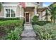 Charming home entrance with a flag, brown door, well-kept shrubbery, and a brick paver walkway at 8111 Pacific Loon St, Winter Garden, FL 34787