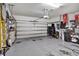 Spacious two car garage with overhead door, storage racks, and workbench at 8111 Pacific Loon St, Winter Garden, FL 34787