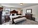 The main bedroom features hardwood floors, a large bed, dark wood furniture, and a large window at 8111 Pacific Loon St, Winter Garden, FL 34787