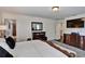 Bright main bedroom featuring dark wood floors, dresser, TV, and an ensuite bathroom at 8111 Pacific Loon St, Winter Garden, FL 34787