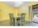Cozy dining room features neutral walls, a chandelier, and sliding glass doors to a patio at 847 Coventry Rd, Davenport, FL 33897