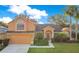 Inviting two-story home with well-maintained landscaping, mature palms, and attached two-car garage at 847 Coventry Rd, Davenport, FL 33897