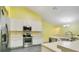 Well-lit kitchen features white cabinets, stainless steel appliances, and functional layout at 847 Coventry Rd, Davenport, FL 33897