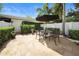 Charming patio with pavers, lush greenery, shade umbrella, and outdoor furniture at 984 Fern Ave, Orlando, FL 32814
