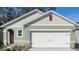 Charming home with a two-car garage, sage green stucco, and contrasting white trim for a clean, modern look at 989 Commons Way, Port Orange, FL 32129