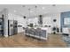 Gourmet kitchen featuring quartz island, pendant lighting, stainless appliances, and modern design at 16238 Misty Hills Ave, Winter Garden, FL 34787