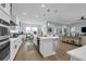 Modern kitchen flows to the living area; with quartz island, sleek appliances, and ample lighting at 16238 Misty Hills Ave, Winter Garden, FL 34787