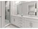 Sleek white bathroom with double sinks, marble countertops, and glass shower at 1014 Jack Nicklaus Ct, Reunion, FL 34747