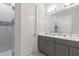 Bathroom featuring a double vanity, a glass shower, and modern fixtures at 1014 Jack Nicklaus Ct, Reunion, FL 34747