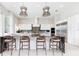 Modern kitchen with white cabinets, a large island, and stylish pendant lighting fixtures at 1014 Jack Nicklaus Ct, Reunion, FL 34747