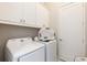Efficient laundry room featuring modern washer and dryer with overhead cabinets for storage at 1014 Jack Nicklaus Ct, Reunion, FL 34747