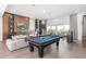 Large entertainment room with a pool table, large TV, and outside access through sliding glass doors at 1014 Jack Nicklaus Ct, Reunion, FL 34747