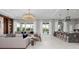 Open-concept living room with a modern chandelier, bar seating, and access to the outdoor patio at 1014 Jack Nicklaus Ct, Reunion, FL 34747