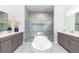 Elegant main bathroom with a soaking tub, dual vanities, and a glass-enclosed shower at 1014 Jack Nicklaus Ct, Reunion, FL 34747