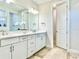 Elegant bathroom featuring double vanity with sleek white cabinets, modern fixtures, and tile floors at 10275 Park Estates Ave, Orlando, FL 32836