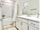 Clean bathroom featuring white cabinetry, a shower with a tub, and neutral colors at 10275 Park Estates Ave, Orlando, FL 32836