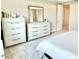 Bright bedroom featuring matching dressers with a large mirror and access to another room through a doorway at 10275 Park Estates Ave, Orlando, FL 32836