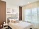 Serene bedroom with wood trim accent wall, featuring a comfortable bed, side tables, and sheer curtains for soft natural light at 10275 Park Estates Ave, Orlando, FL 32836