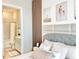 Bedroom with wood trim accent wall featuring a comfortable bed, side tables, and an open door to the ensuite bathroom at 10275 Park Estates Ave, Orlando, FL 32836