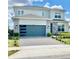 Two-story home with a modern garage door, stone accents, manicured landscaping, and a paver driveway at 10275 Park Estates Ave, Orlando, FL 32836