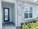 Home entryway with a black-framed door, stone accents, a welcome mat, and lush landscaping at 10275 Park Estates Ave, Orlando, FL 32836