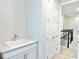 Hallway with a sink and white cabinets, leading to a staircase and additional rooms, offering convenience and style at 10275 Park Estates Ave, Orlando, FL 32836