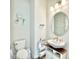 Bright powder room with a stylish oval mirror, modern sink, and elegant leaf-patterned wallpaper at 10275 Park Estates Ave, Orlando, FL 32836