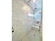 Walk-in shower with gray tile, a built-in bench, recessed storage, and multiple shower heads at 10275 Park Estates Ave, Orlando, FL 32836