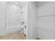 Bathroom view featuring marble-style tile, a shower-tub, and closet shelving at 104 Alta Vista Way, Davenport, FL 33837