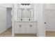 This bathroom features double sinks with sleek black faucets, a modern mirror, and a door to the shower at 104 Alta Vista Way, Davenport, FL 33837