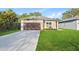 Welcoming exterior of a home with a tidy lawn and attached two car garage at 104 Alta Vista Way, Davenport, FL 33837