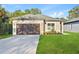 Inviting single-Gathering home with a lush lawn, long driveway, and attached garage at 104 Alta Vista Way, Davenport, FL 33837