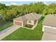 Aerial view of new home with neutral exterior, tidy landscaping, and green grass at 104 Alta Vista Way, Davenport, FL 33837